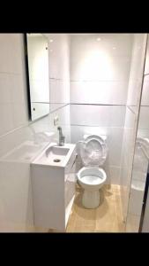 a white bathroom with a toilet and a sink at Sunny Garden. YBG. 1 Bedroom Apt. Quiet in Tel Aviv