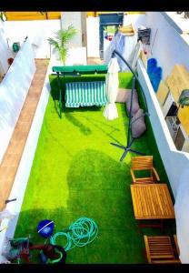 Sunny Garden. YBG. 1 Bedroom Apt. Quiet في تل أبيب: حديقة صناعية مع مقاعد وكراسي على مبنى