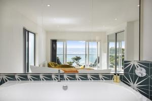 a bathroom with a tub with a view of the ocean at Turnstone in Torpoint