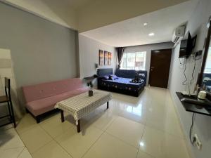 a living room with a couch and a table at KK City A2Z Api Api Studio Homestay in Kota Kinabalu