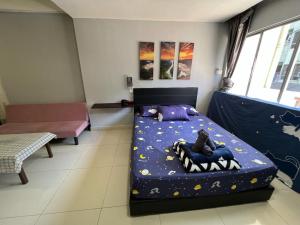 a bedroom with a bed with a cat on it at KK City A2Z Api Api Studio Homestay in Kota Kinabalu