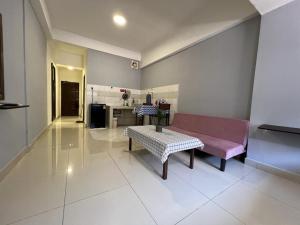 a living room with a pink bench and a kitchen at KK City A2Z Api Api Studio Homestay in Kota Kinabalu