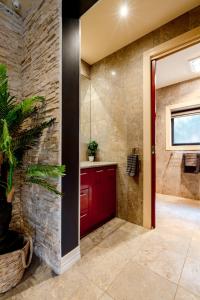 a bathroom with a red door and a plant at A Touch of Red - Spa, Theatre, Sleeps 6! in Waurn Ponds