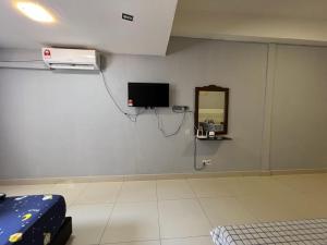 a room with a tv and a mirror on the wall at KK City A2Z Api Api Studio Homestay in Kota Kinabalu