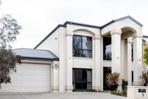 a white house with a garage at A Touch of Red - Spa, Theatre, Sleeps 6! in Waurn Ponds