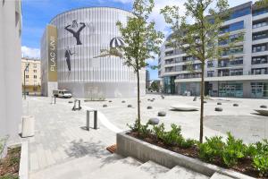 a building with a courtyard with trees in front of it at Apartment with Balcony Gdynia Downtown by Renters in Gdynia