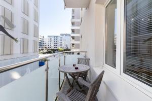 a balcony with a table and chairs and a window at Apartment with Balcony Gdynia Downtown by Renters in Gdynia