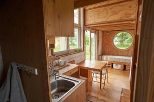 una cucina con lavandino e tavolo in una casetta minuscola di Tiny house near the Mont-Saint-Michel a Ducey