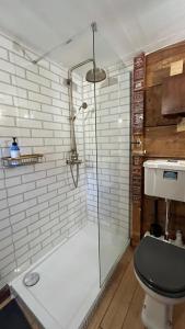 牛頓阿伯特的住宿－Remarkable Boultons Barn with hot tub，浴室设有玻璃淋浴间和卫生间