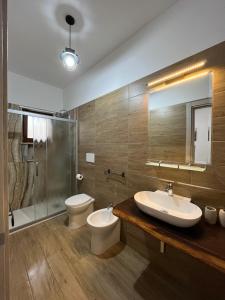 bagno con lavandino, servizi igienici e specchio di La Chianconata a Vieste