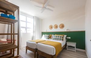 een slaapkamer met een groot bed met een groene muur bij Dodo Square in Grand Baie