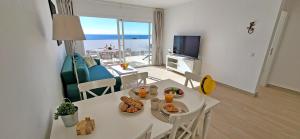 a living room with a white table with food on it at Ferienwohnung OCEAN SOUNDS 2 in Gran Tarajal