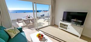 a living room with a television and a view of the ocean at Ferienwohnung OCEAN SOUNDS 2 in Gran Tarajal