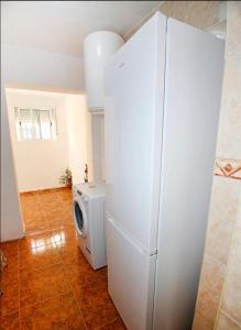 a white refrigerator in a room with a tile floor at CASA JARDIN DE MAR in Torrevieja