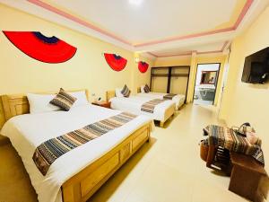 a hotel room with two beds and a television at Happy Family Hotel in Sa Pa