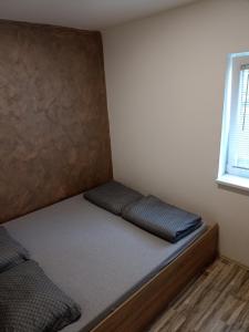 Vikendica apartments Dunav MS في Čelarevo: غرفة صغيرة مع سرير في الزاوية