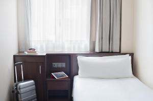 a hotel room with two beds and a window at Hotel Lugano Barcelona in Barcelona