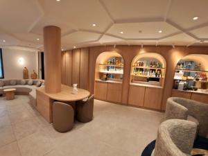 a room with a bar with couches and a table at Mercure Paris Arc de Triomphe Wagram in Paris