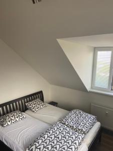 1 dormitorio con 2 camas y ventana en Horský apartmán pod Ještědem, en Liberec