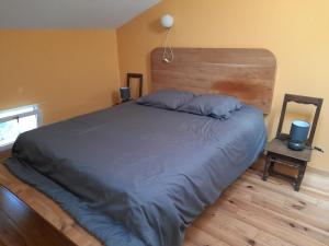 a bedroom with a large bed with a wooden headboard at Maison entière avec petite cour intérieure. in Monthureux-sur-Saône