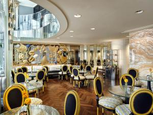 a restaurant with tables and chairs and a large mirror at Park Hyatt Vienna in Vienna