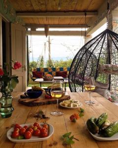 una mesa con dos copas de vino y verduras. en Skijis Sakhli, en Zenobani