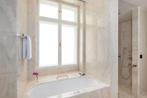 a bathroom with a bath tub and a window at Park Hyatt Vienna in Vienna