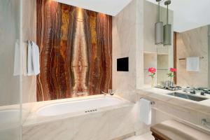 a bathroom with a tub and a sink at Park Hyatt Vienna in Vienna