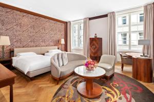 a hotel room with a bed and a couch and a table at Park Hyatt Vienna in Vienna