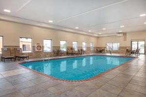einen Pool in einer Hotellobby mit Tischen und Stühlen in der Unterkunft Hampton Inn St. Louis/Collinsville in Collinsville