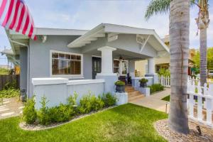 a house with a white fence and a palm tree at Cozy Craftsman Bungalow, Hillcrest/Mission Hills in San Diego