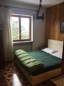 a bedroom with a green bed and a window at Zeta House in Rivisondoli