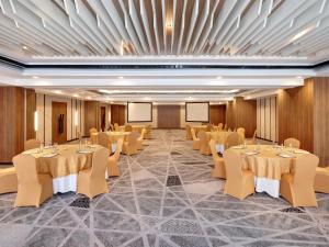 a banquet hall with tables and chairs in a room at Novotel Bali Ngurah Rai Airport in Kuta