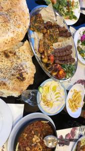 a table topped with different types of food and plates of food at Bahaa in Jerash