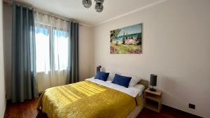 een slaapkamer met een bed en een schilderij aan de muur bij Mala Italia Apartments in Wrocław