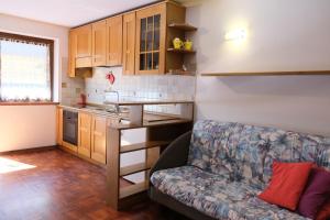 a living room with a couch and a kitchen at Appartamento Madiai in Canazei