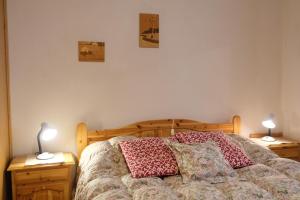 um quarto com uma cama com 2 candeeiros em mesas de cabeceira em Appartamento Madiai em Canazei