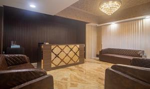 a waiting room with two leather couches and a chandelier at Treebo Trend Address Inn Jubilee Hills in Hyderabad