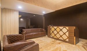 a room with two leather couches and a wall at Treebo Trend Address Inn Jubilee Hills in Hyderabad