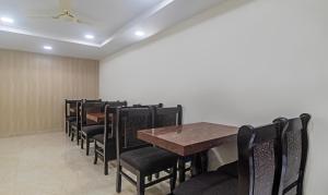 a dining room with tables and black chairs at Treebo Trend Address Inn Jubilee Hills in Hyderabad