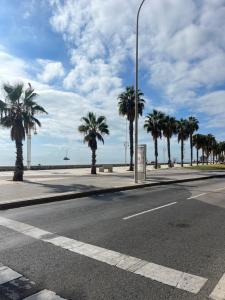 an empty street with palm trees on the beach at Apartamento La Marquesa in Málaga