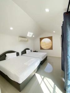 een slaapkamer met 2 bedden en een raam erin bij โรงแรมราชิการีสอร์ท in Khon Kaen