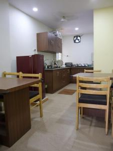 a kitchen with wooden cabinets and a table and chairs at Libra Cottage in Port Blair