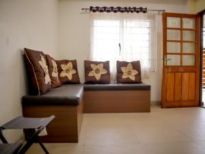 a couch sitting in a room with a window at Libra Cottage in Port Blair