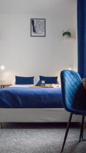 a bedroom with a blue bed and a blue chair at Mile Gdansk Airport in Gdańsk