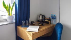 a wooden table with a blue chair next to a window at Mile Gdansk Airport in Gdańsk