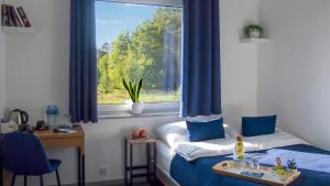a room with two beds and a window with blue curtains at Mile Gdansk Airport & Parking Długoterminowy in Gdańsk
