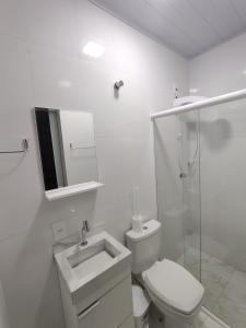 a white bathroom with a toilet and a sink at Casa paraíso estaleirinho Balneário Camboriú in Balneário Camboriú