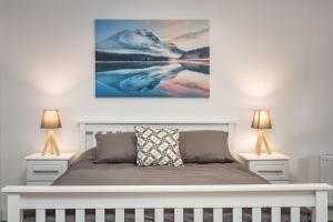 a bedroom with a white bed with two lamps at Walled City Apartments in Derry Londonderry