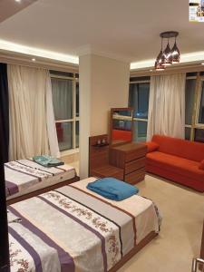 a bedroom with two beds and a red couch at شقه اكثر روعه فيو بحر مباشر in Alexandria